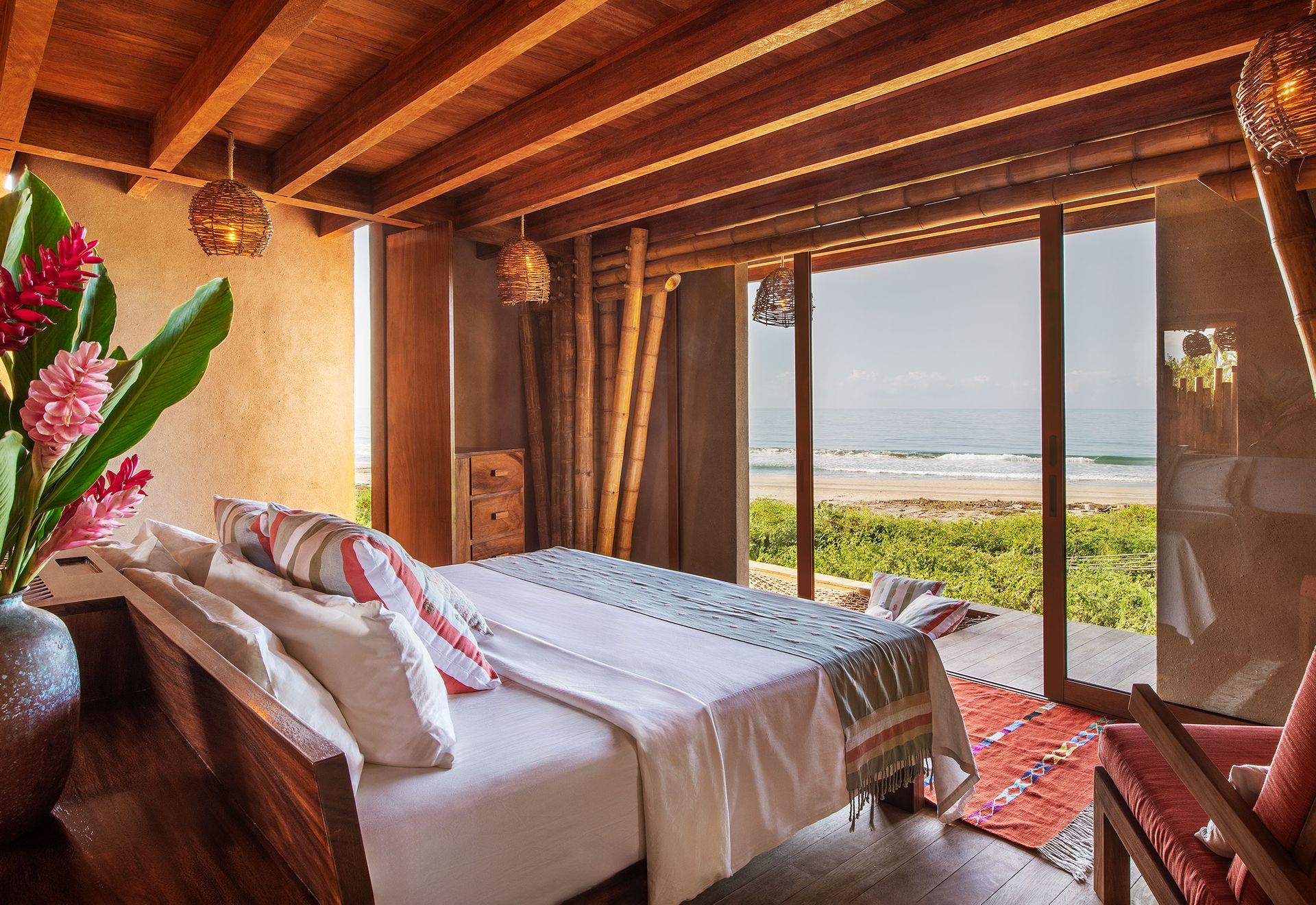 A bedroom with a large bed and a view of the ocean.