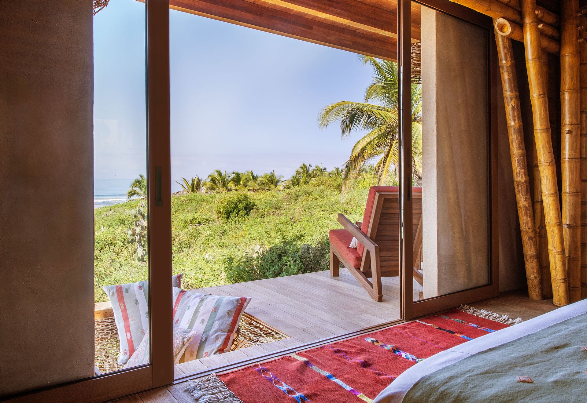 A bedroom with a sliding glass door leading to a balcony.