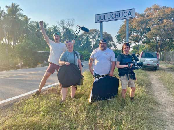 A group of people are standing next to a road holding cameras.