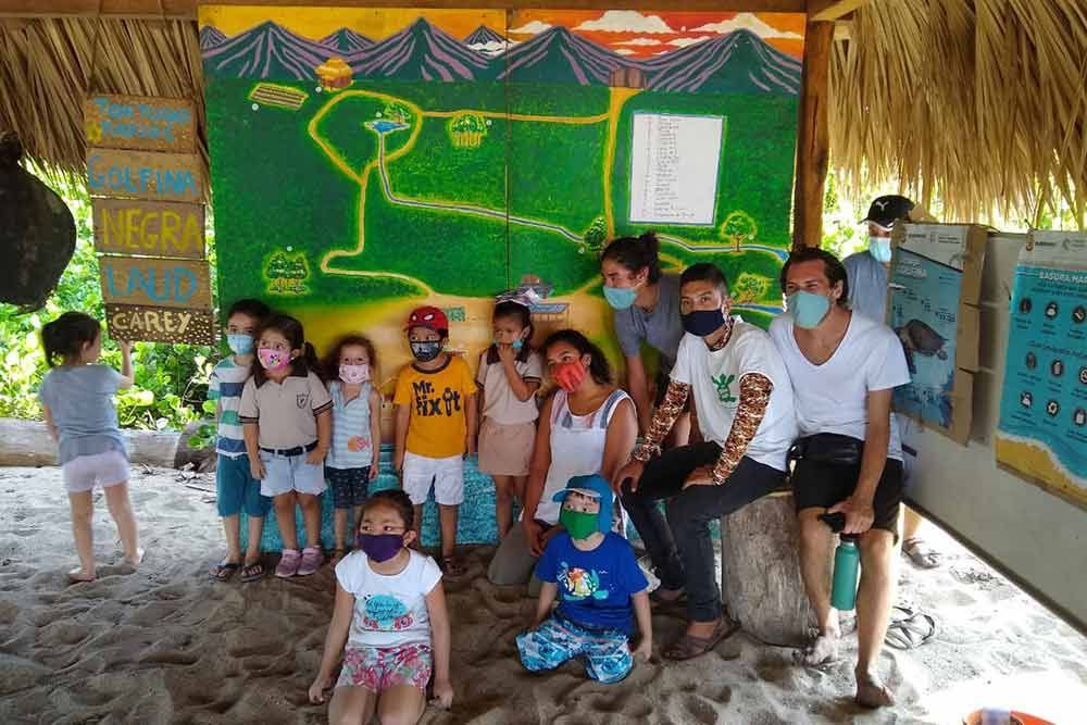 A group of people wearing face masks are posing for a picture
