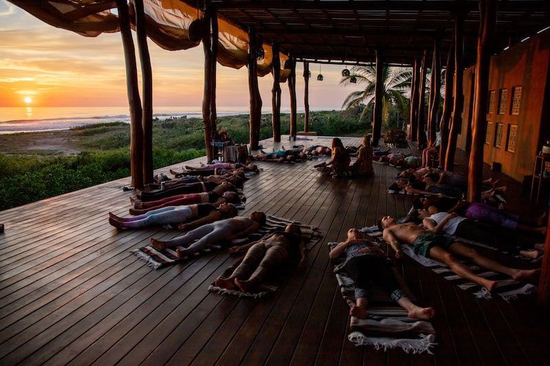 A group of people are laying on their stomachs on a wooden deck.