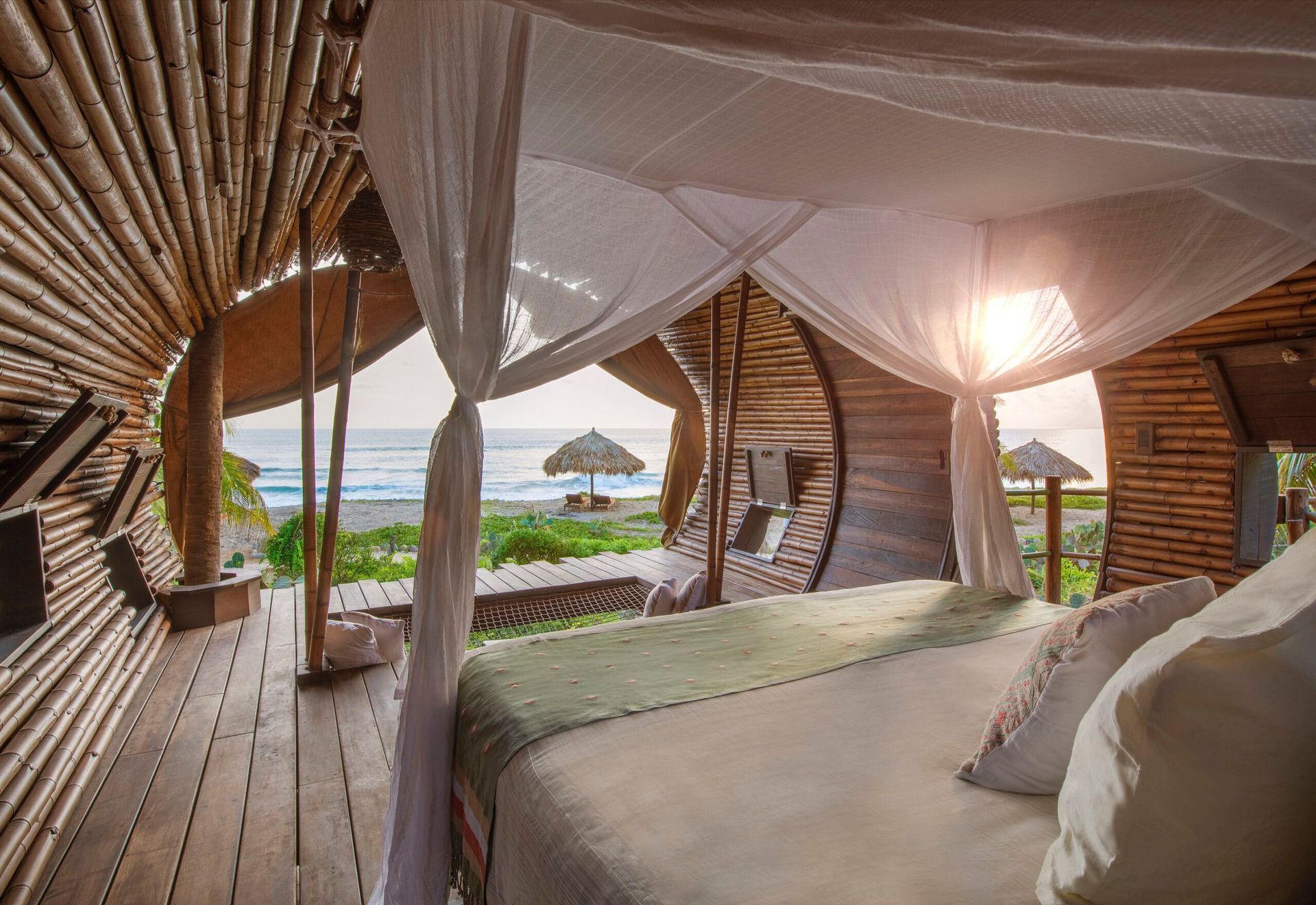 A bedroom with a canopy bed and a view of the ocean.