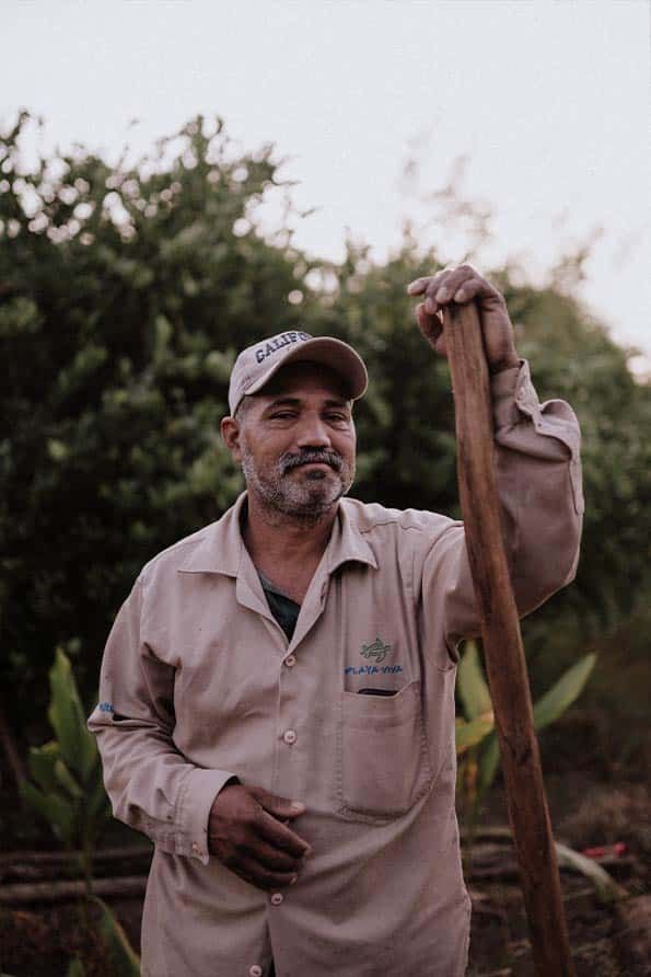 A man with a beard is holding a wooden stick in his hand.