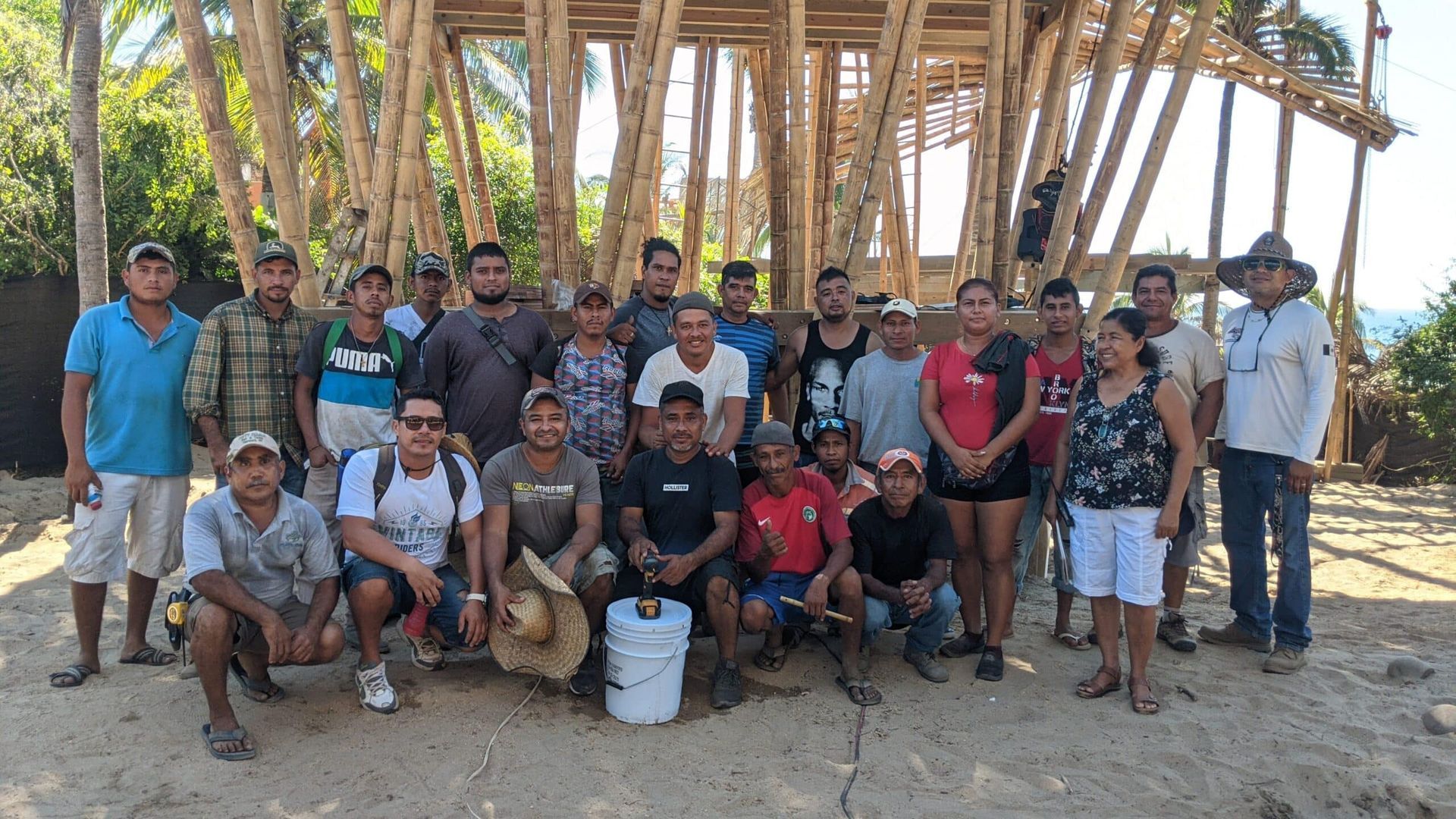 A group of people are posing for a picture in front of a wooden structure.