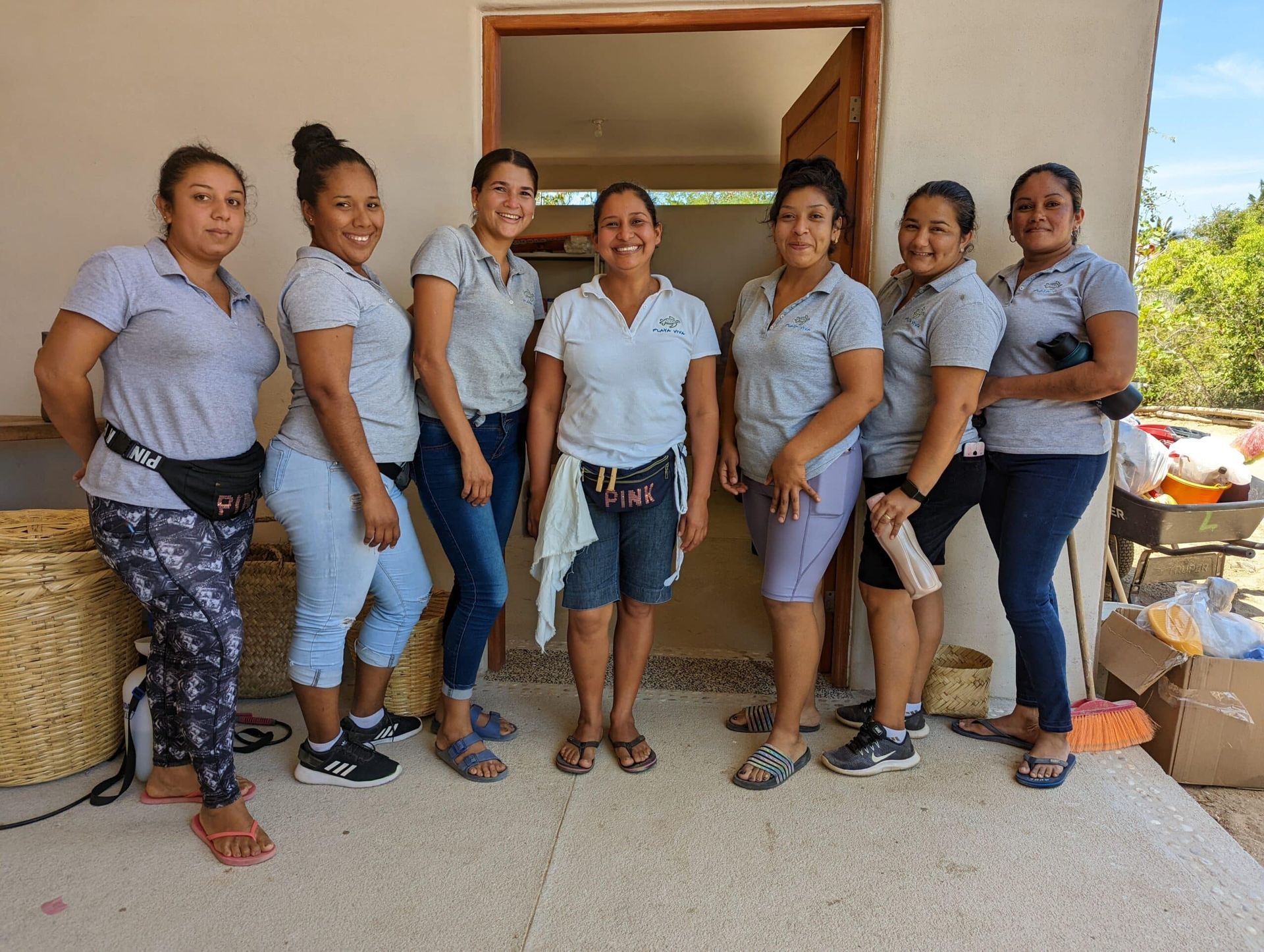 A group of women are posing for a picture in front of a building.
