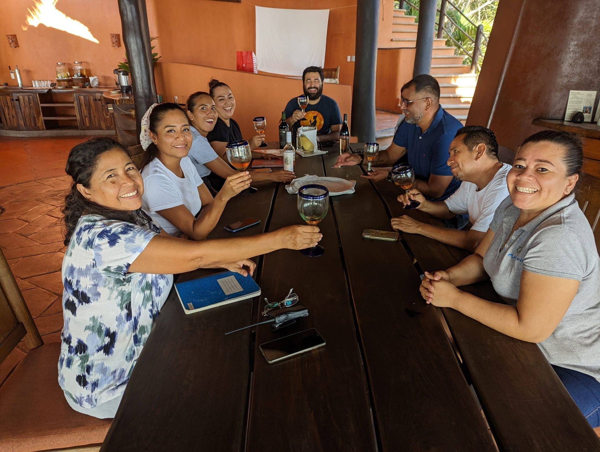 A group of people are sitting around a wooden table.