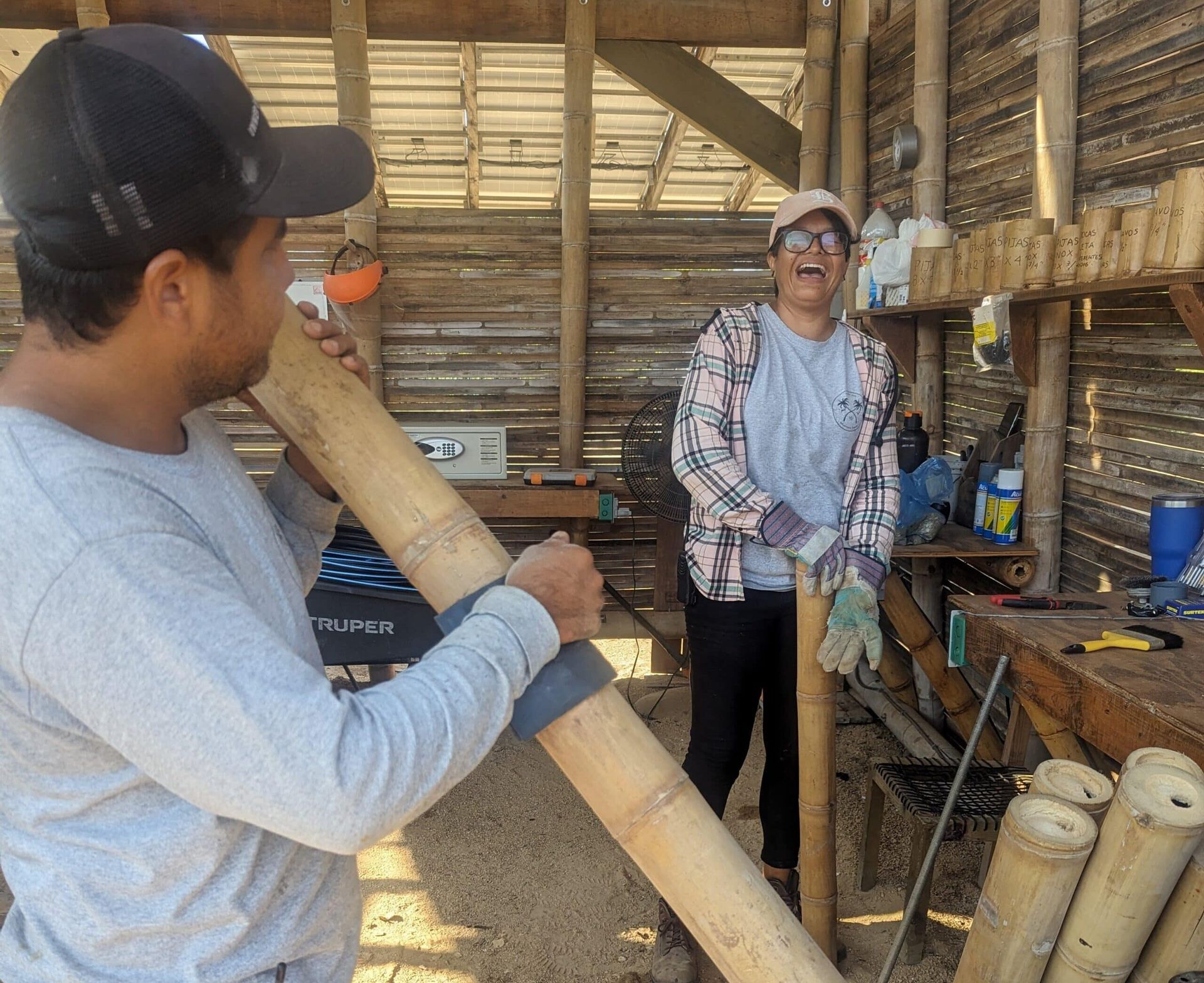 A man in a baseball cap is holding a large bamboo pole