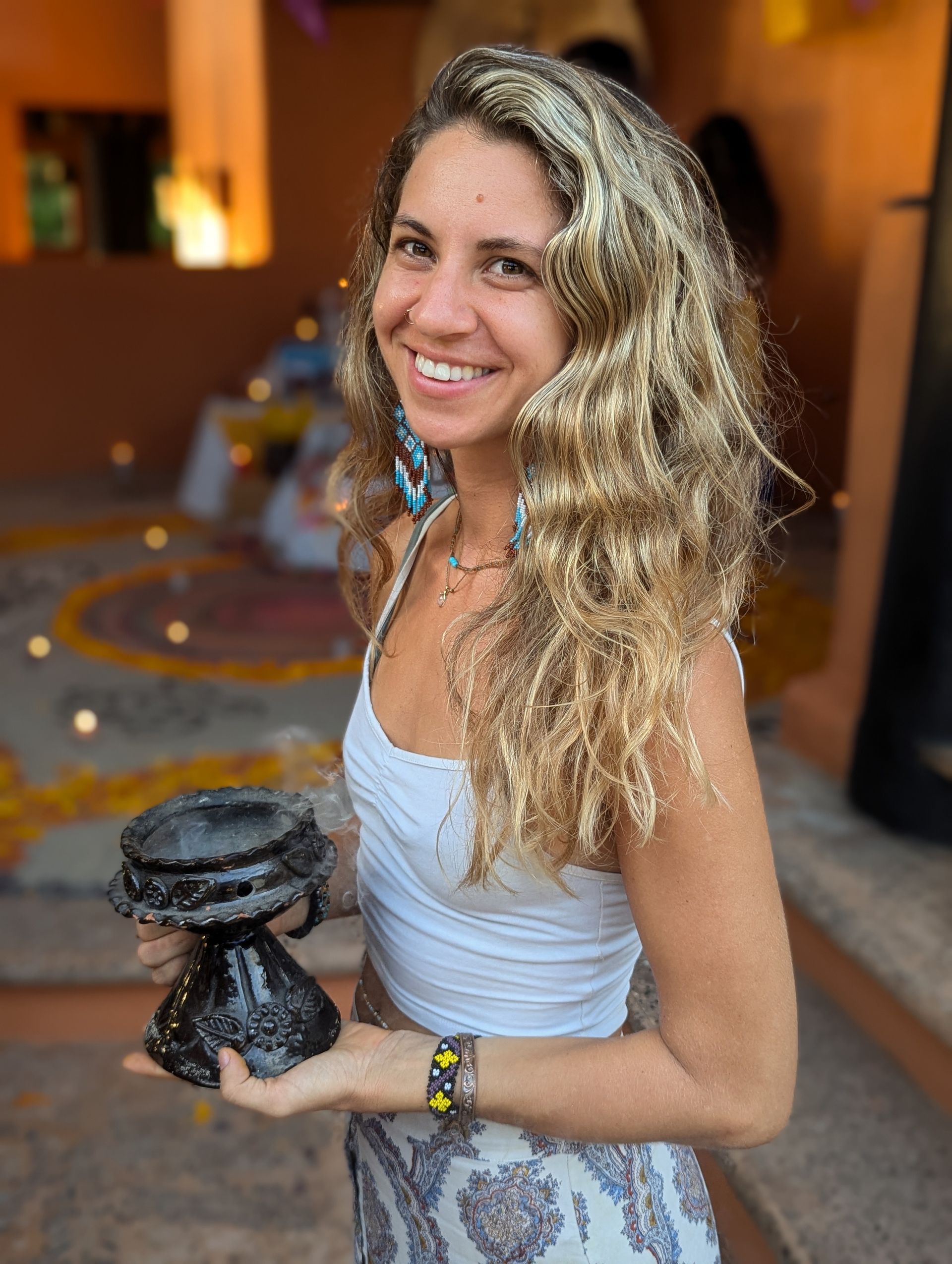 Two women are sitting on a yoga mat on a wooden deck.