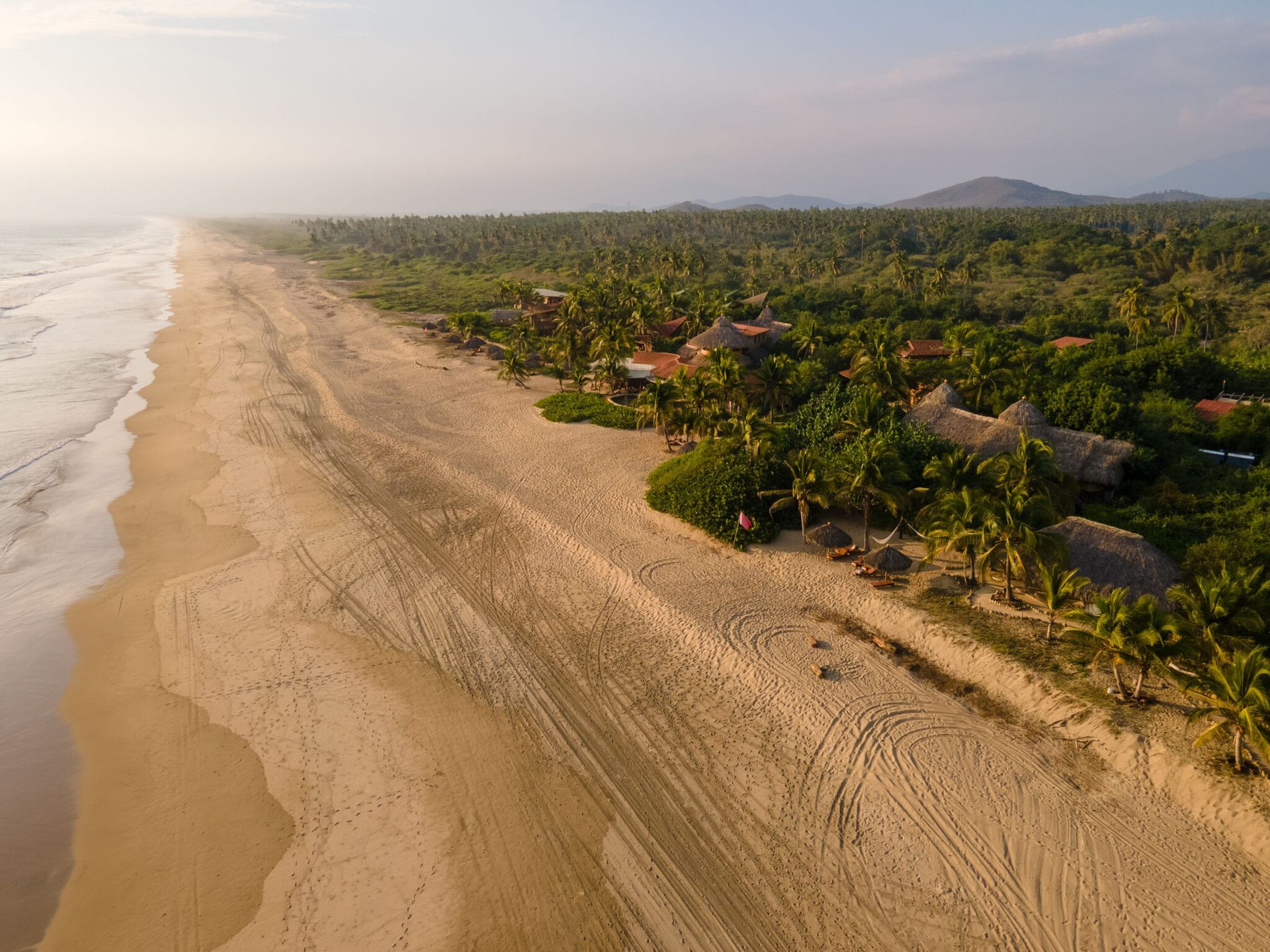 A woman is walking along a sandy beach.