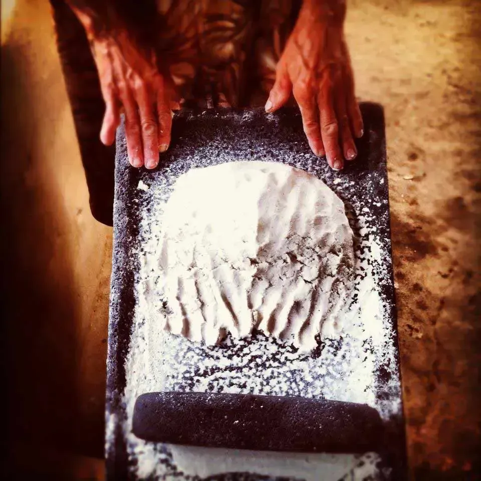 A person is rolling a piece of dough on a table