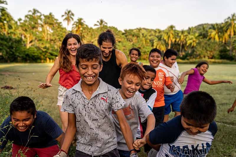 A group of children are holding hands in a field.