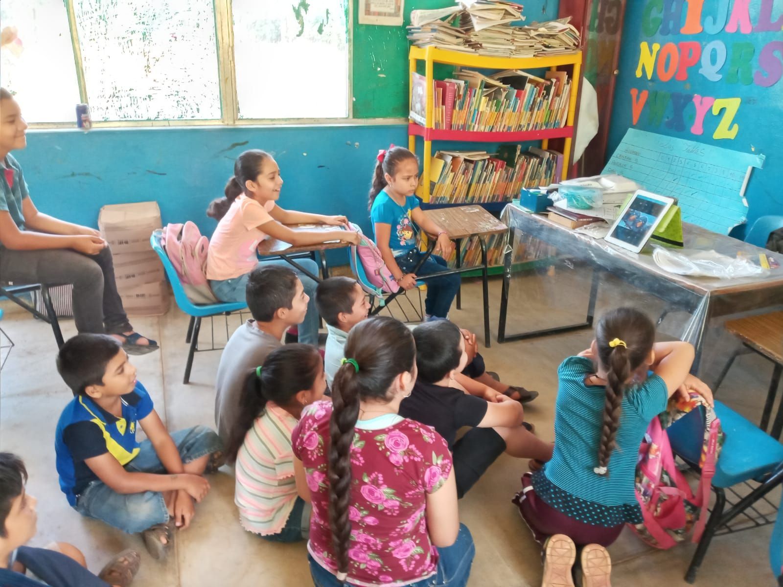A group of children are sitting on the floor in a library
