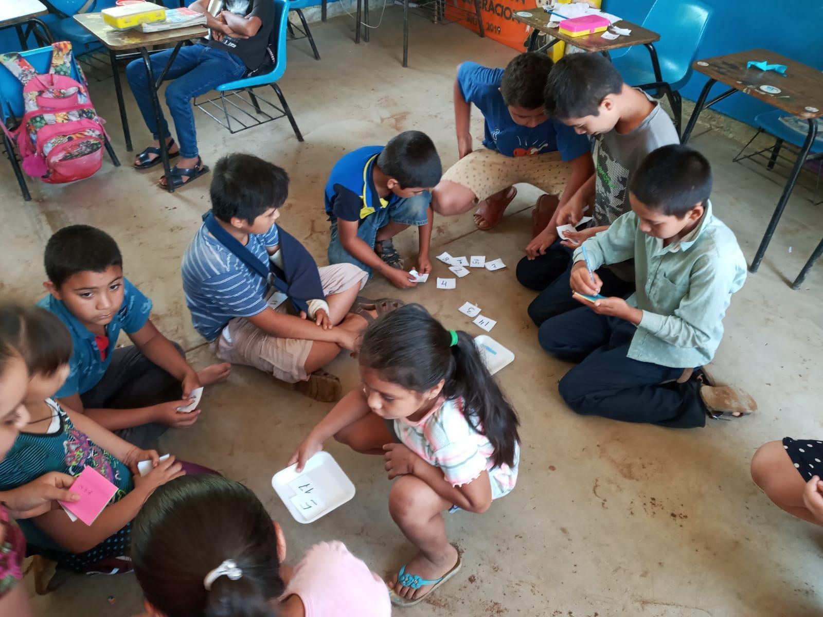 A group of children are playing cards in a classroom