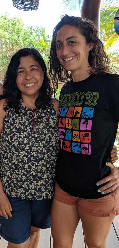 Two women are standing next to each other and smiling for the camera.