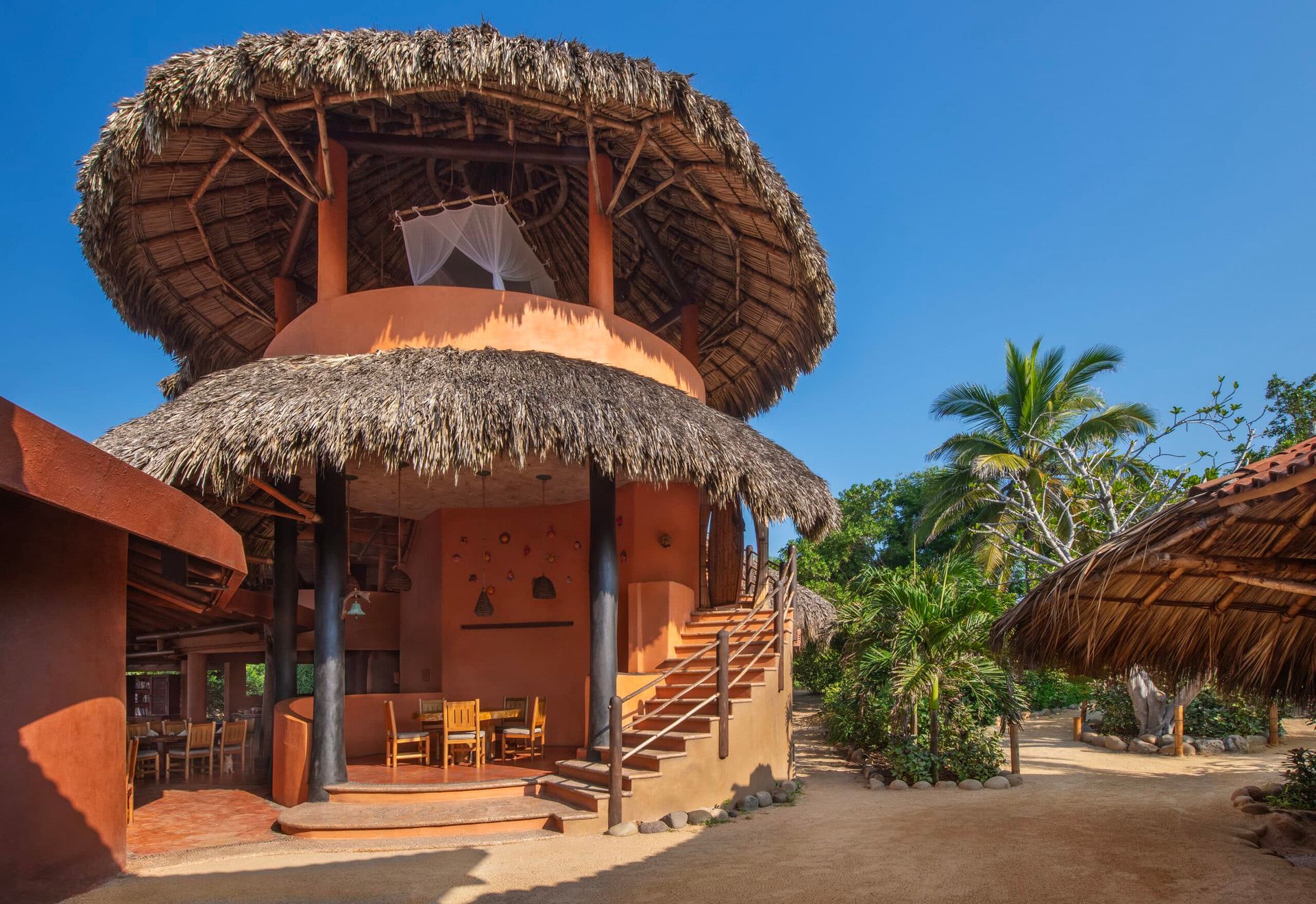A thatched roofed building with stairs leading up to it
