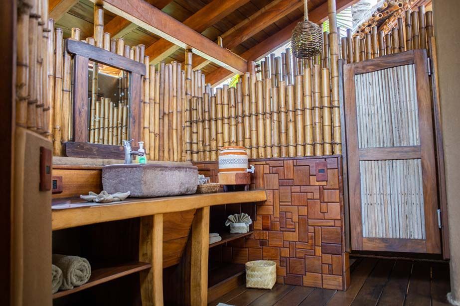 A bathroom with a sink and a mirror surrounded by bamboo.
