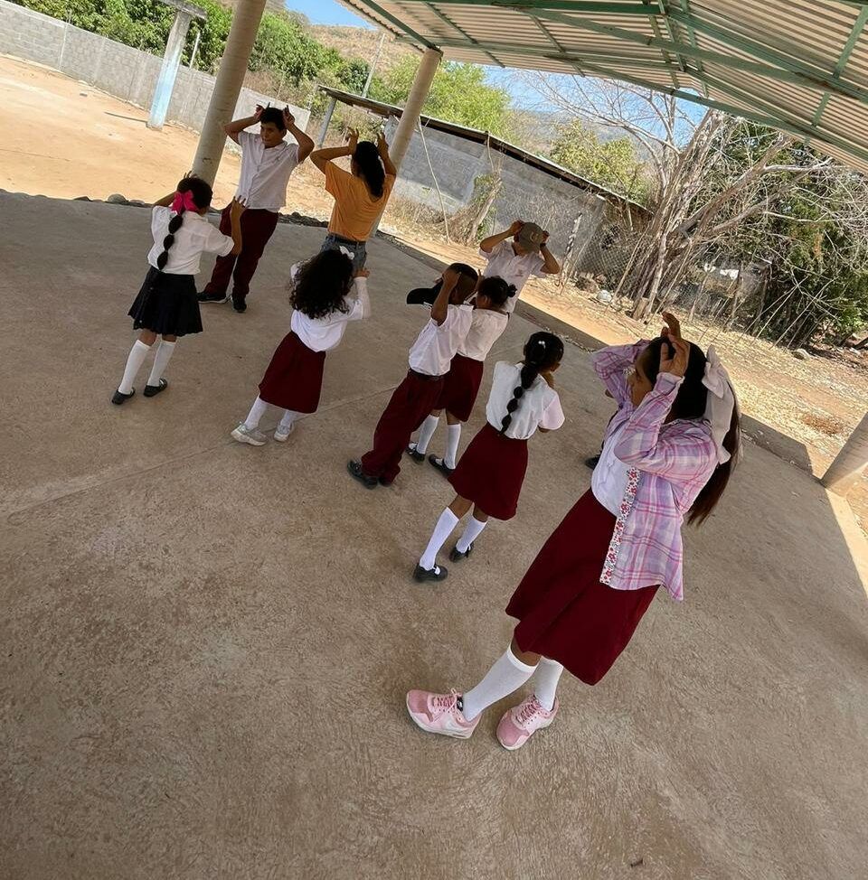A group of children are dancing under a canopy