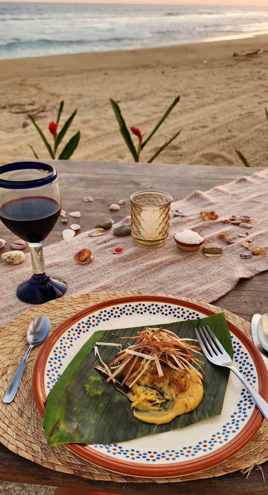 A plate of food is sitting on a table next to a glass of wine.