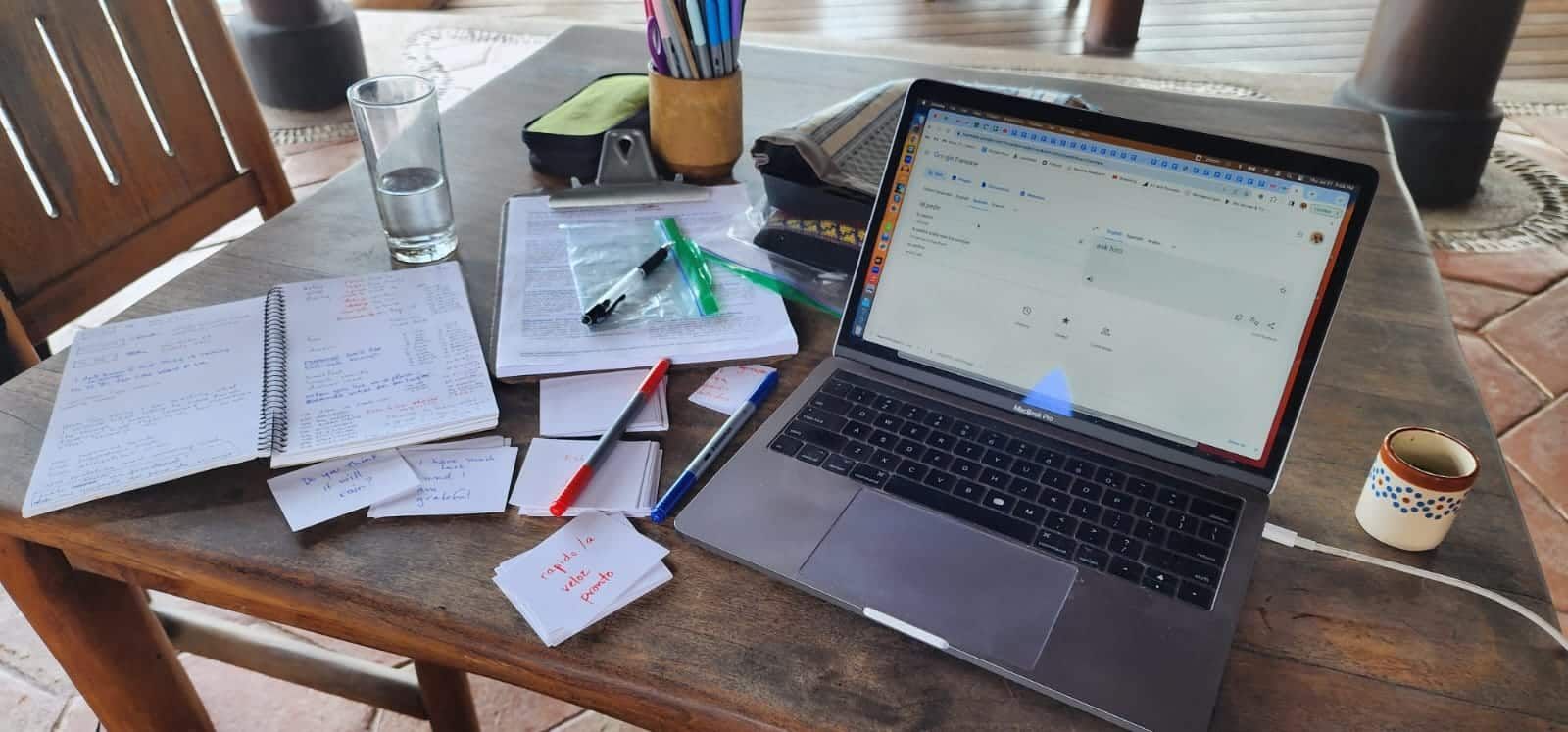 A laptop computer is sitting on top of a wooden table.