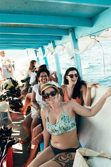 A group of women are sitting on a boat in the ocean.
