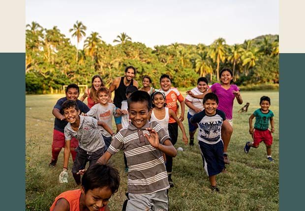 A group of children are running in a field.