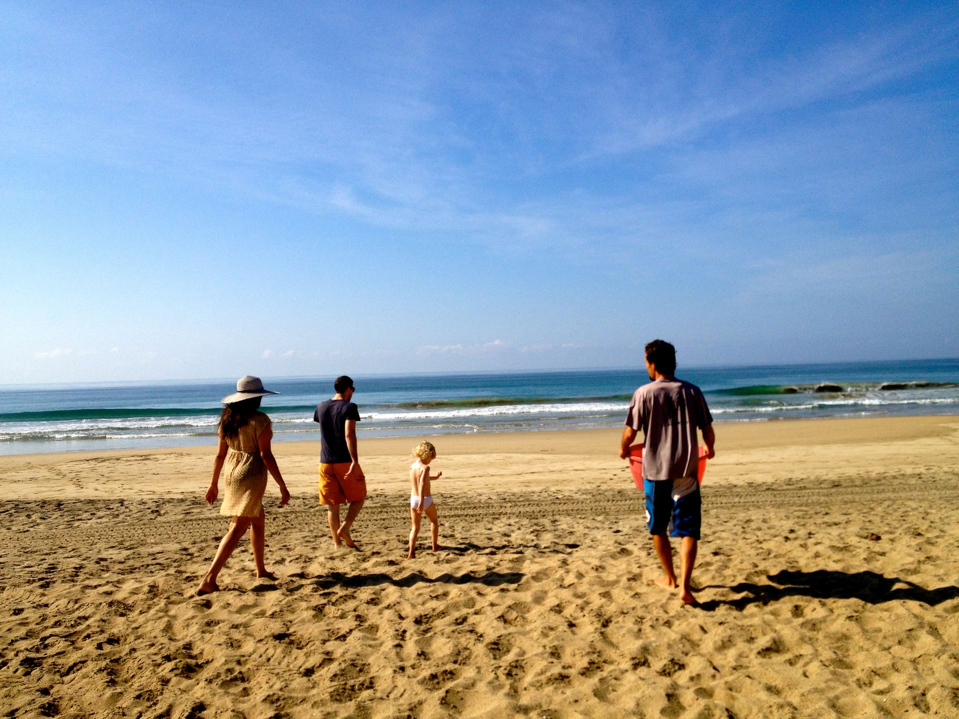 A group of people are walking on a sandy beach.