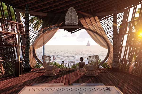 A man is sitting in a chair in a room with a view of the ocean.