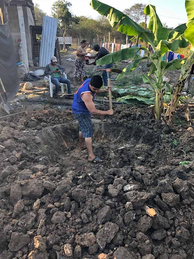 A man is digging in the dirt with a shovel.