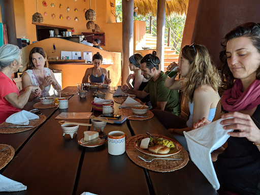 A group of people are sitting around a table with plates of food on it.