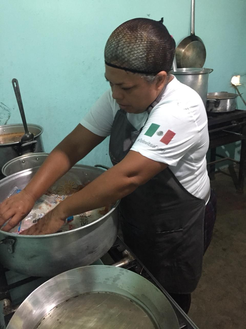 A woman wearing an apron with the mexican flag on it