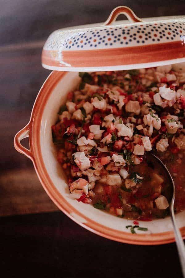 A bowl of soup with a lid and a spoon in it.