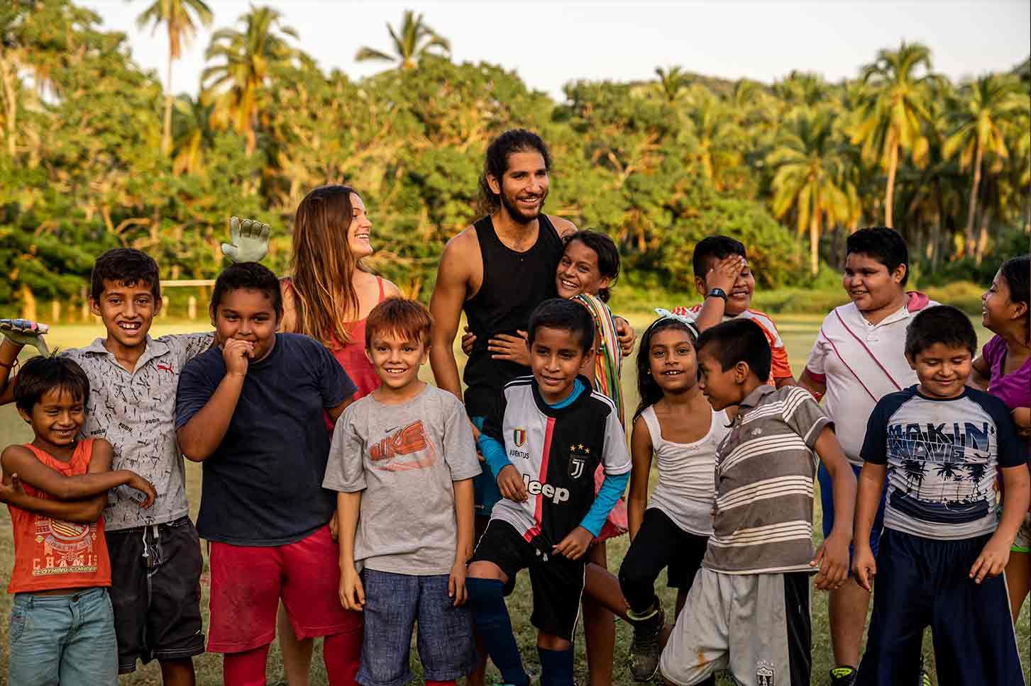 A group of children are posing for a picture in a field.