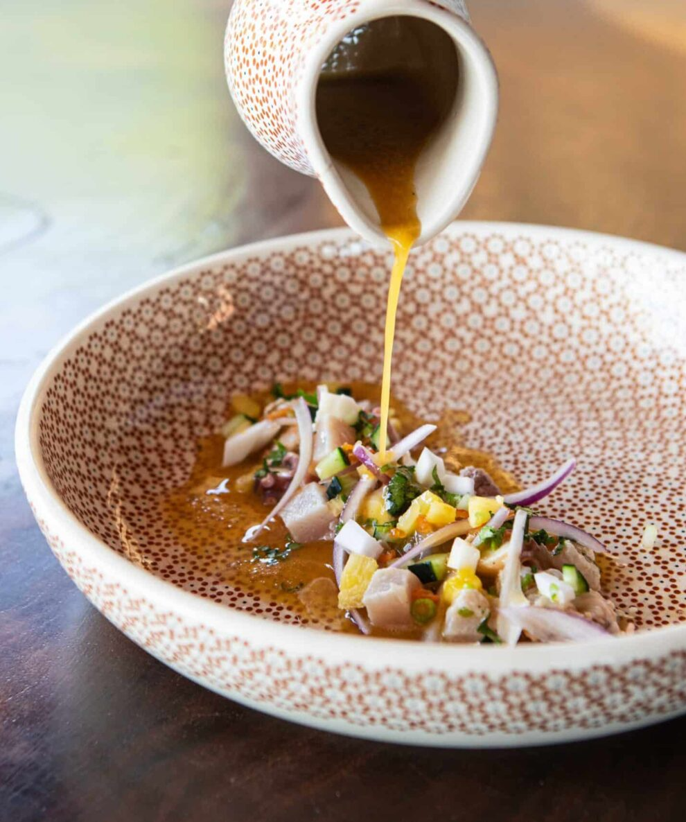 A bowl of soup with a lid and a spoon in it.