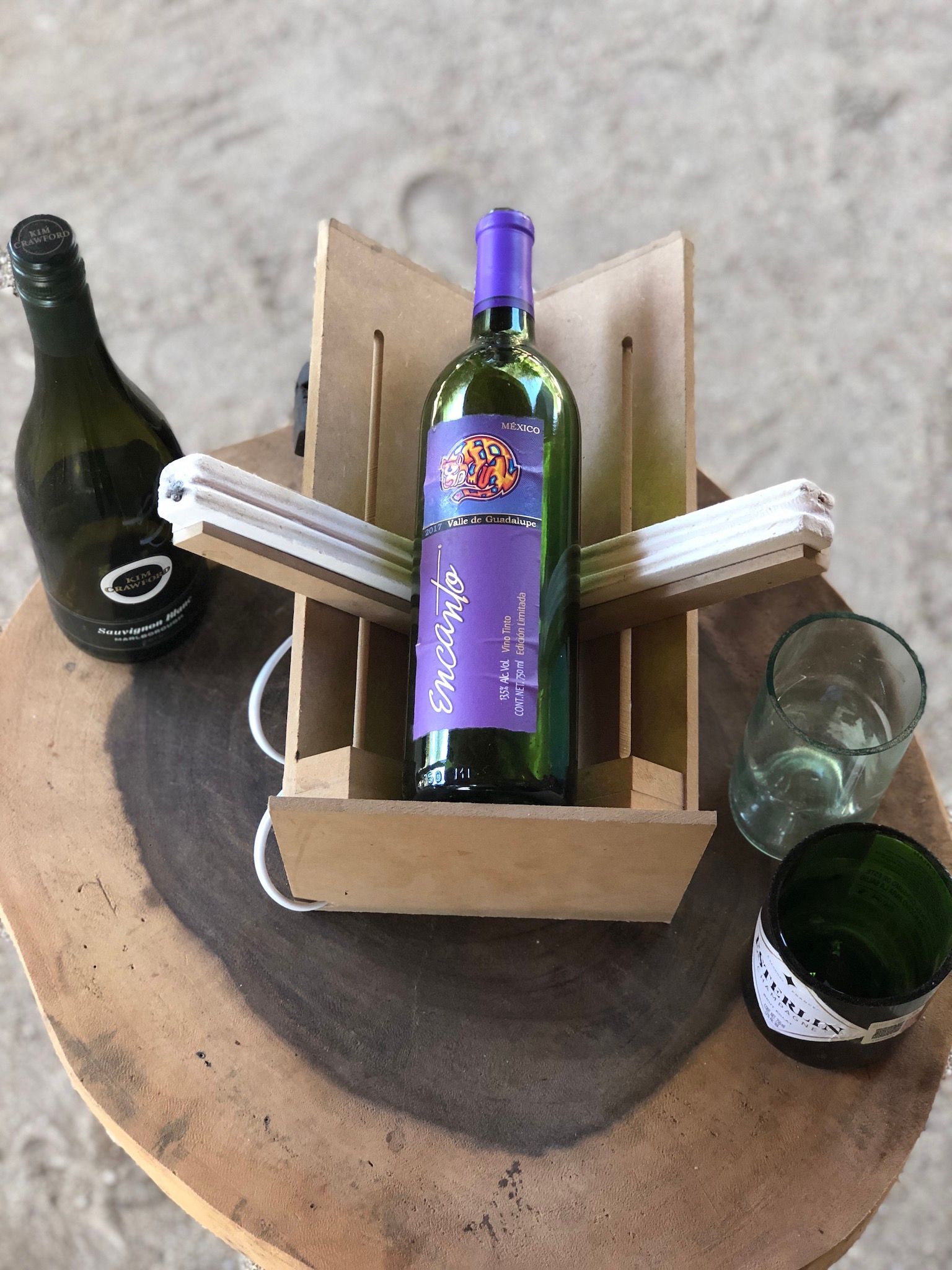 A bottle of wine is sitting in a wooden box on a wooden table.