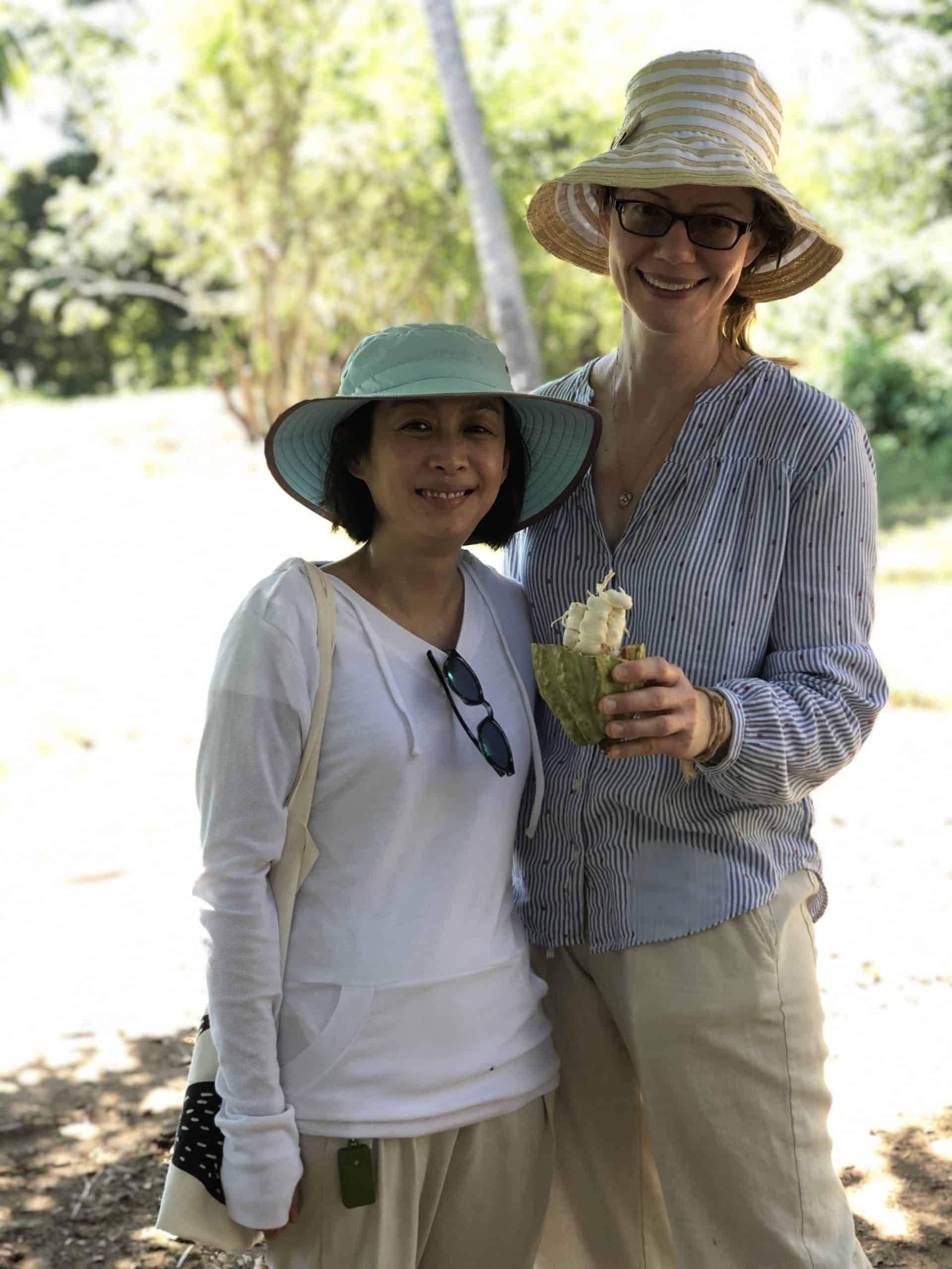 Two women wearing hats and sunglasses are posing for a picture.
