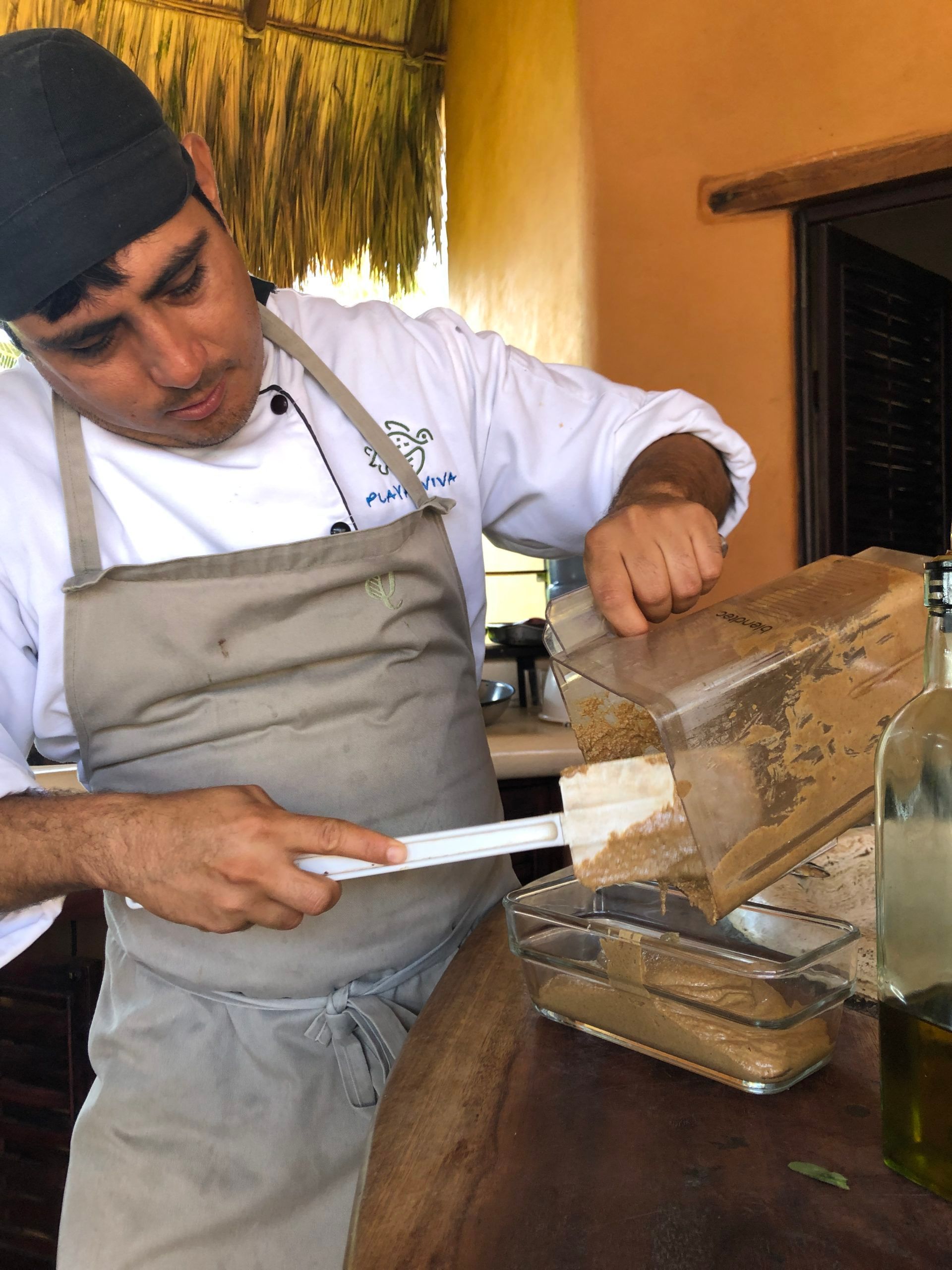 A man in an apron is preparing food in a kitchen