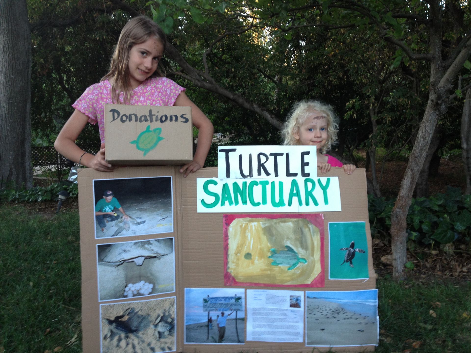 Two young girls holding a sign that says turtle sanctuary