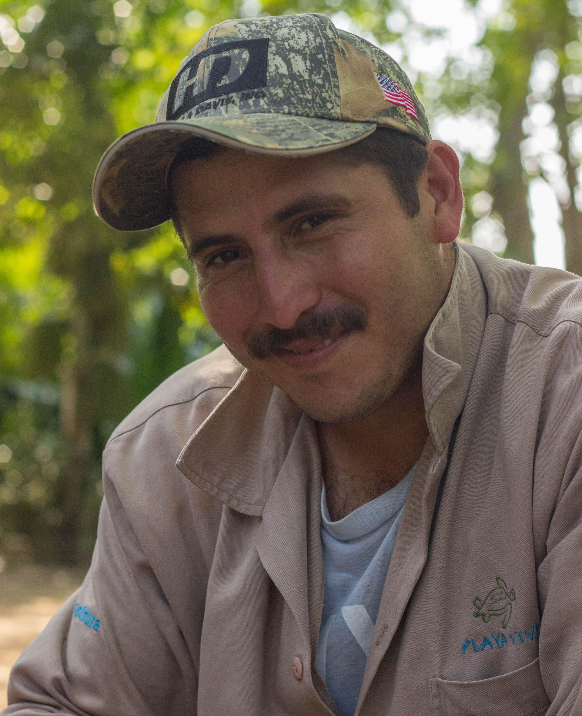A man with a mustache wearing a hat and a jacket