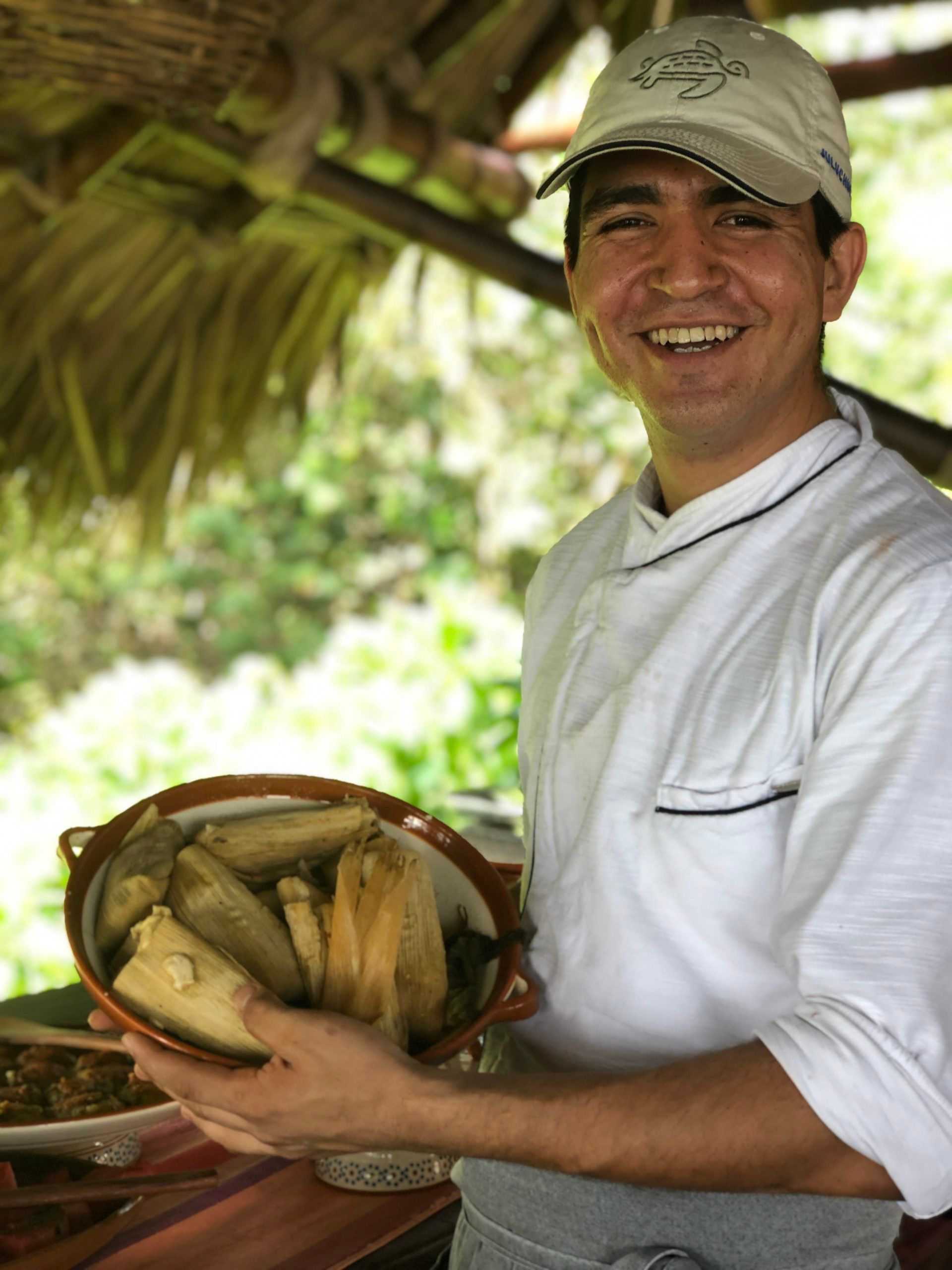 A man is holding a bowl of food and smiling.