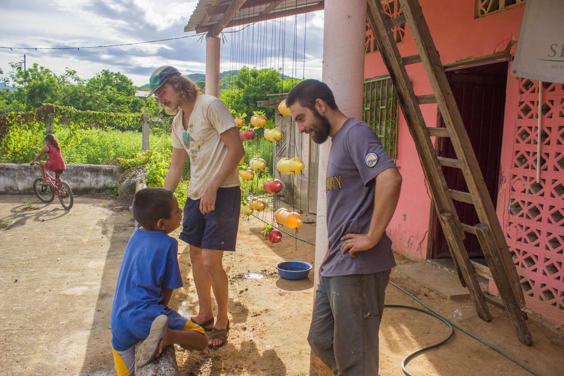 A group of people are standing next to each other in front of a pink building.