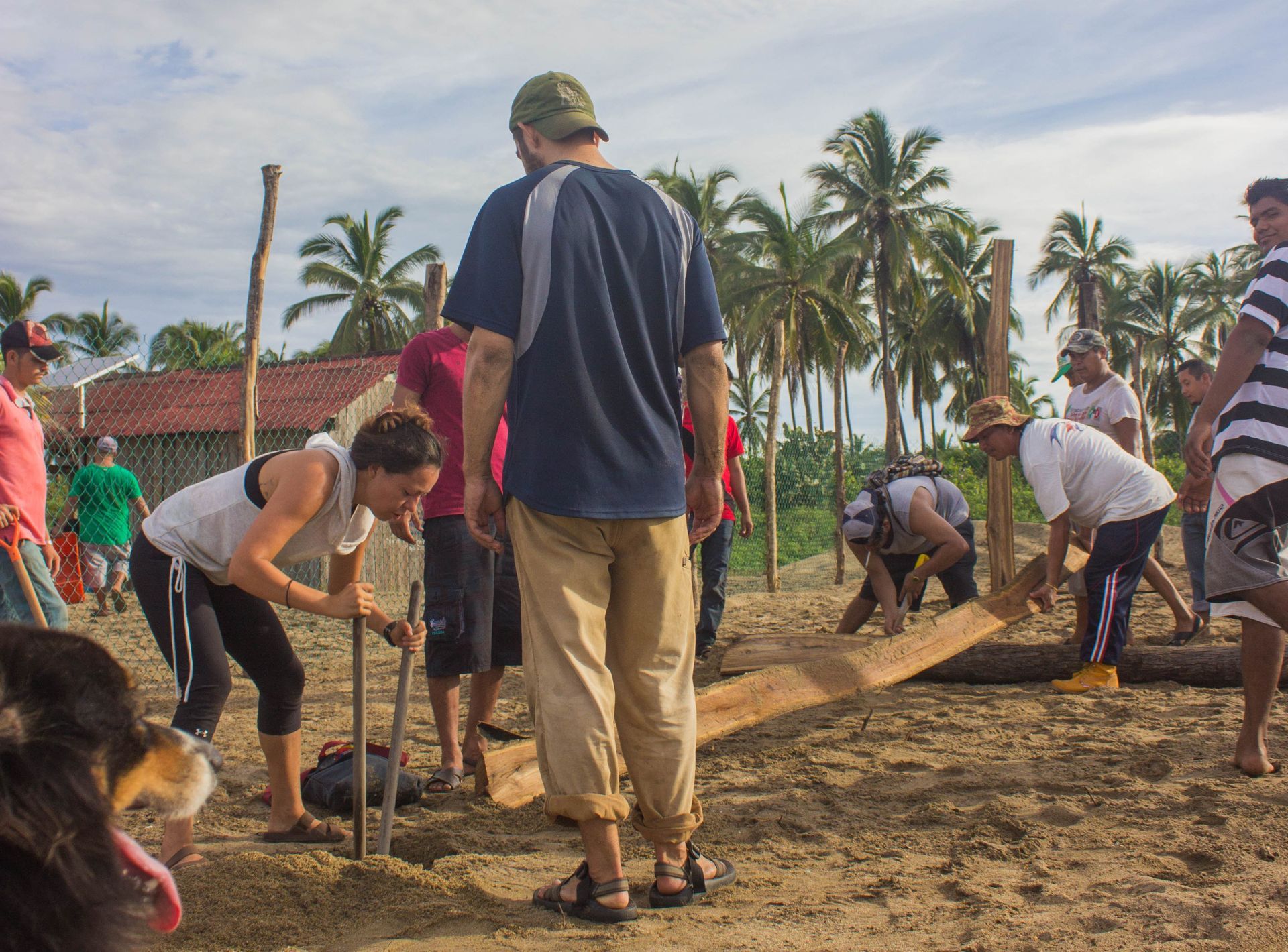 A group of people are working in the dirt on a beach.