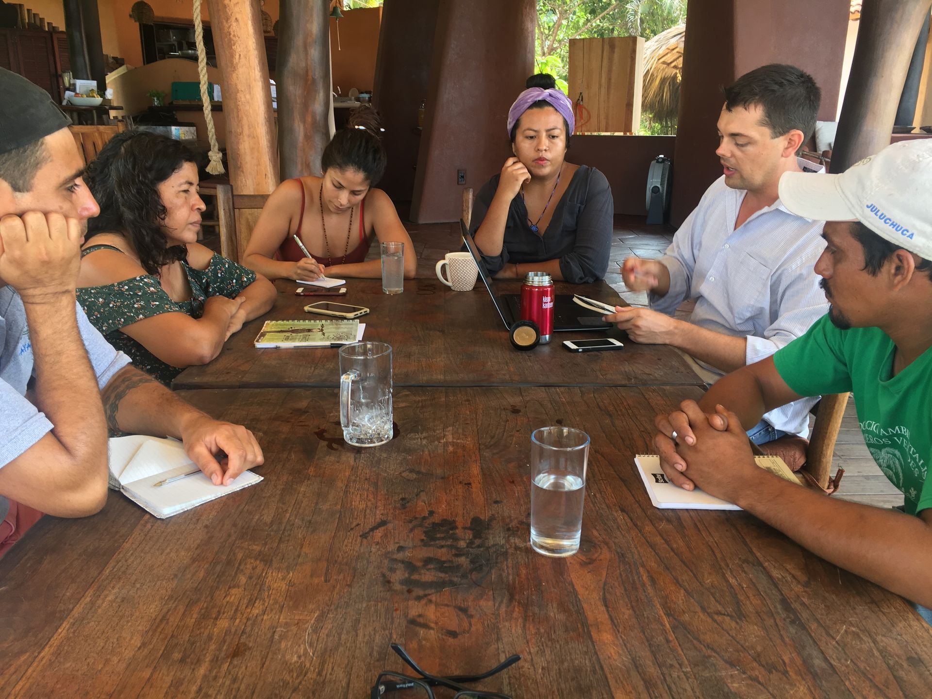 A group of people are sitting around a wooden table