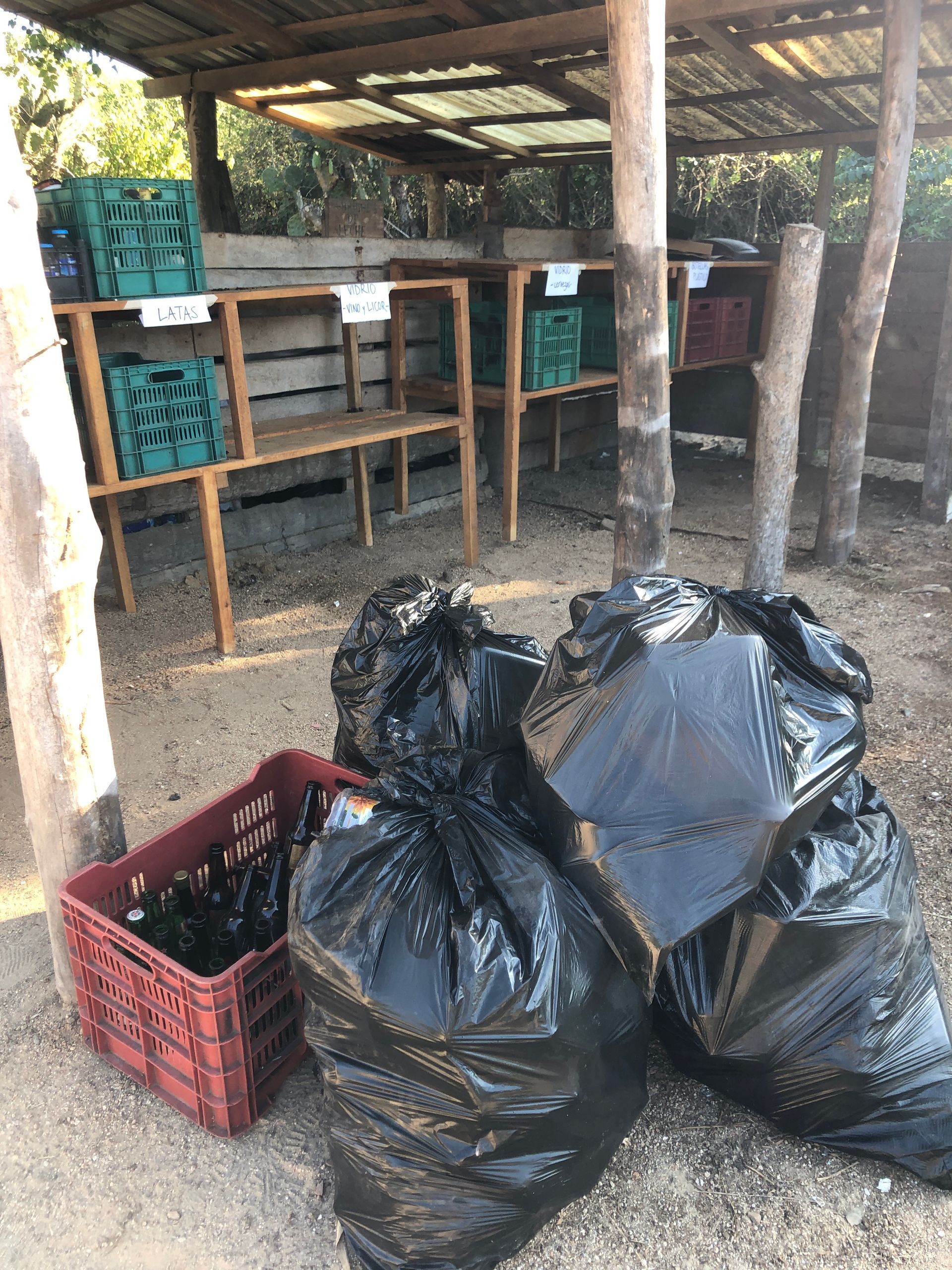 A pile of trash bags sitting next to a red crate.