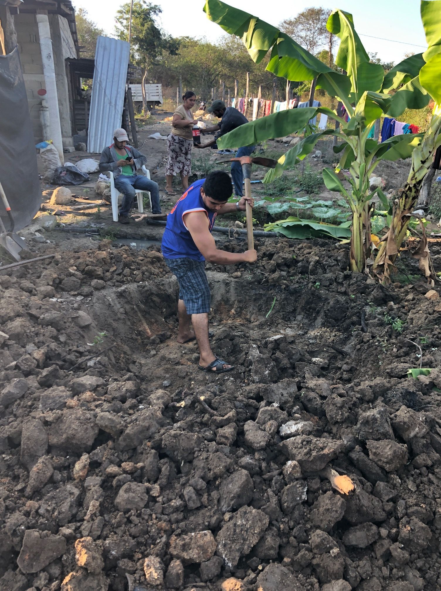 A man is digging in the dirt with a hammer.