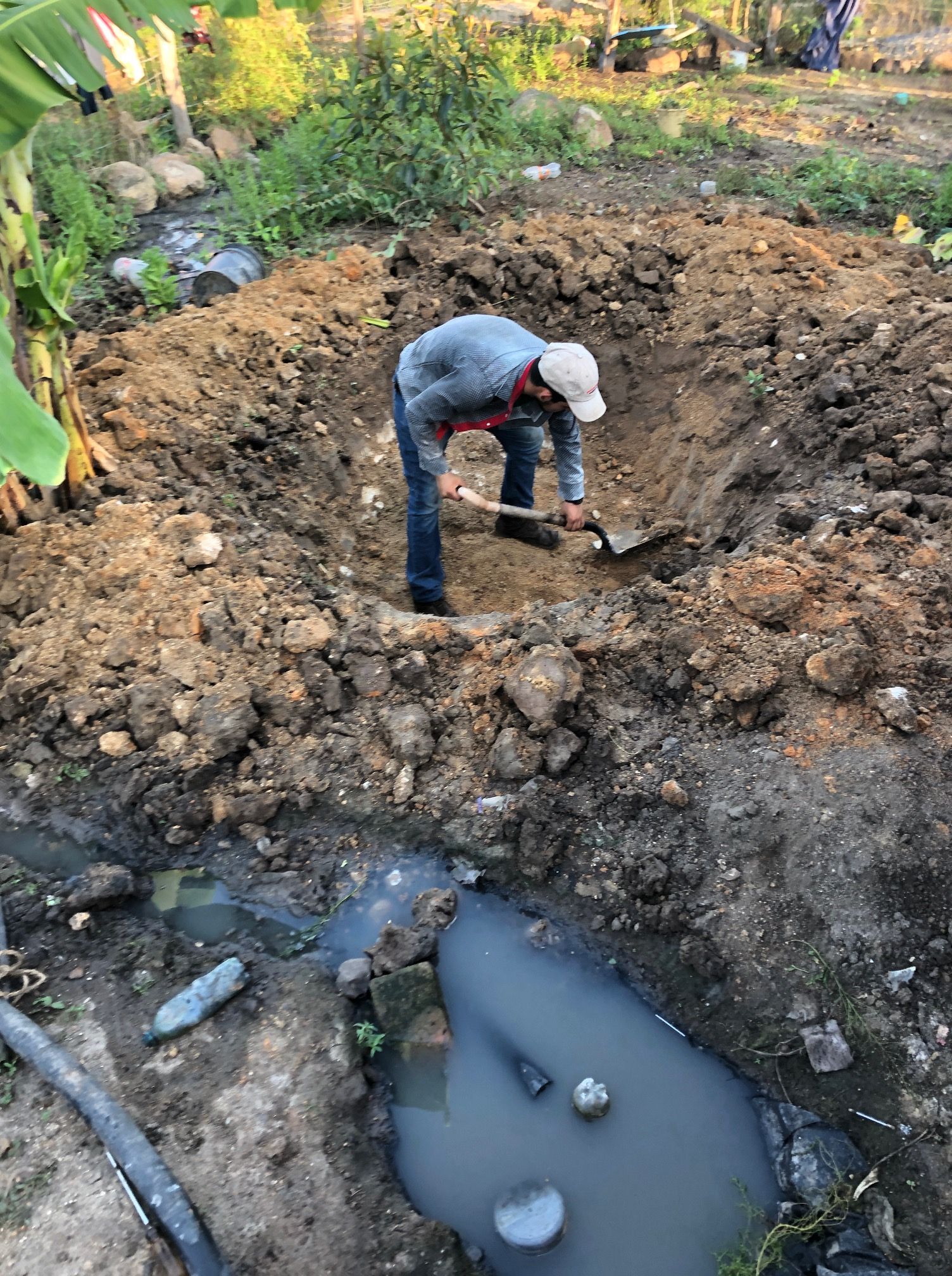 A man is digging in the dirt with a shovel.
