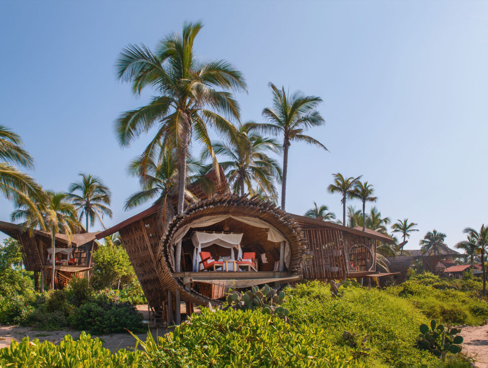 A wooden house with a balcony overlooking the ocean.