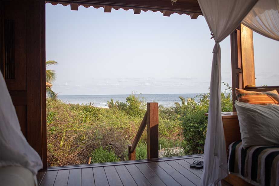 A bedroom with a canopy bed and a view of the ocean.