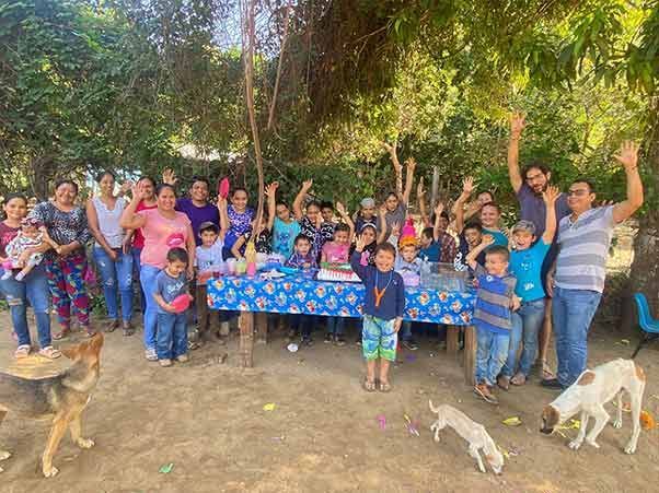 A group of people are standing around a table with their arms in the air.