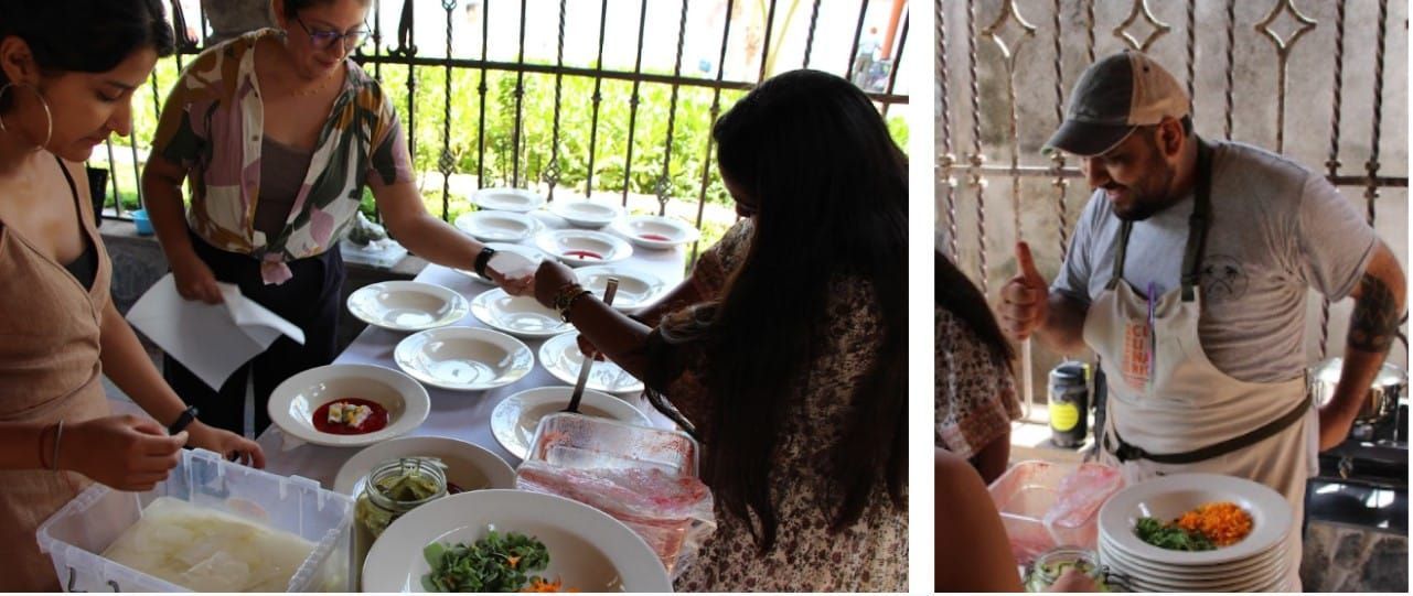 A group of people are standing around a table with plates of food.