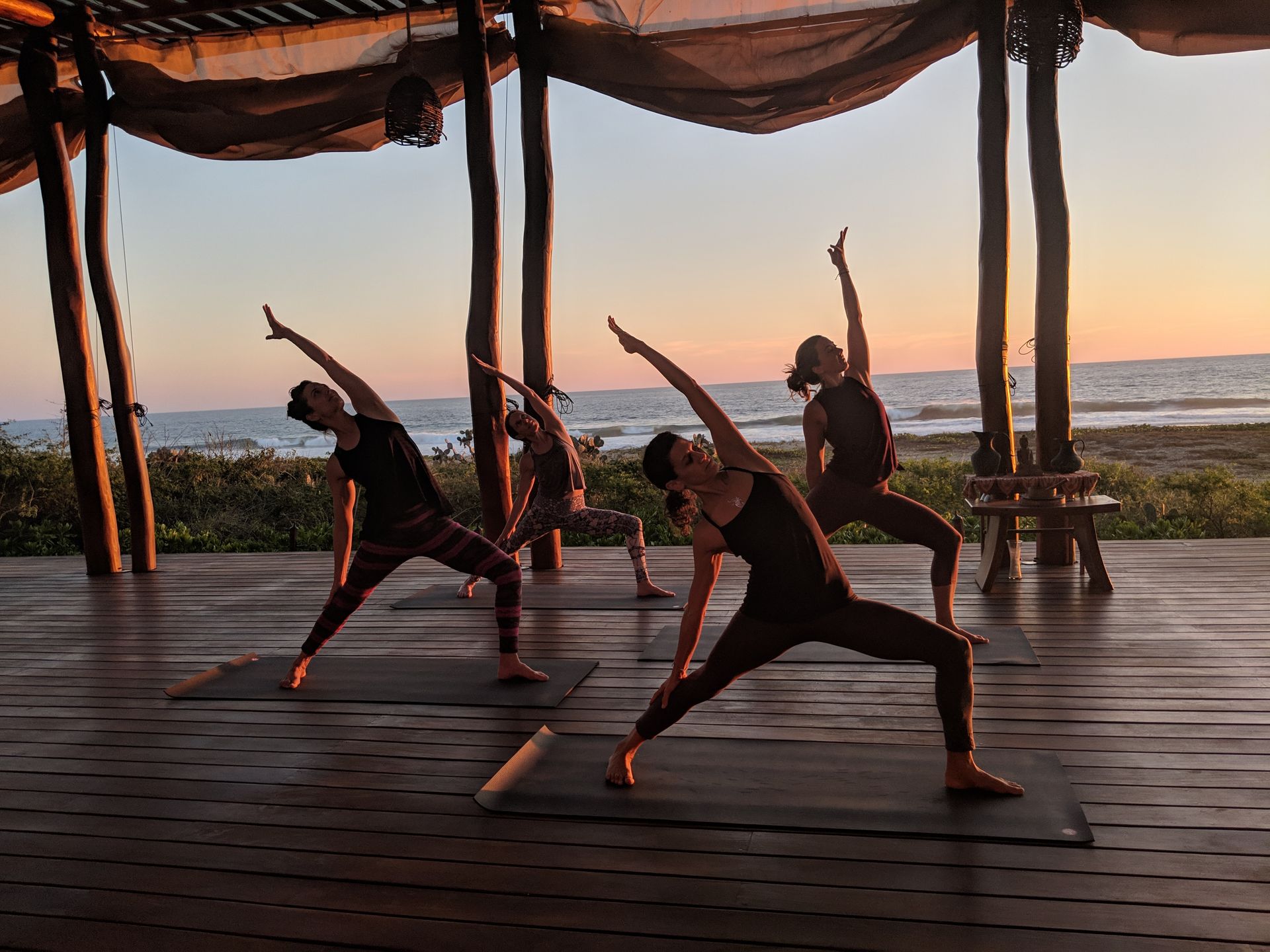 A group of people are doing yoga on a wooden deck.